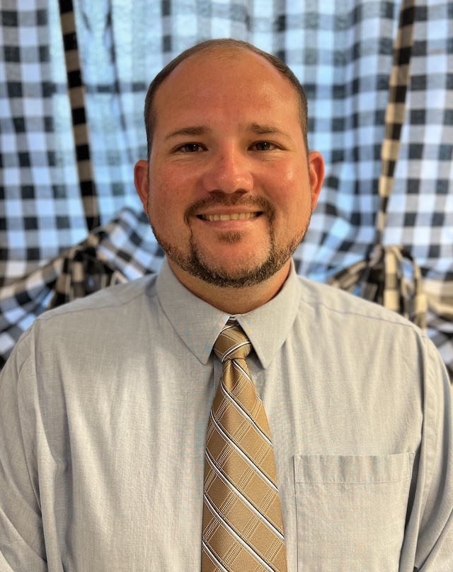 Jamie Ham smiling in front of a patterned wall